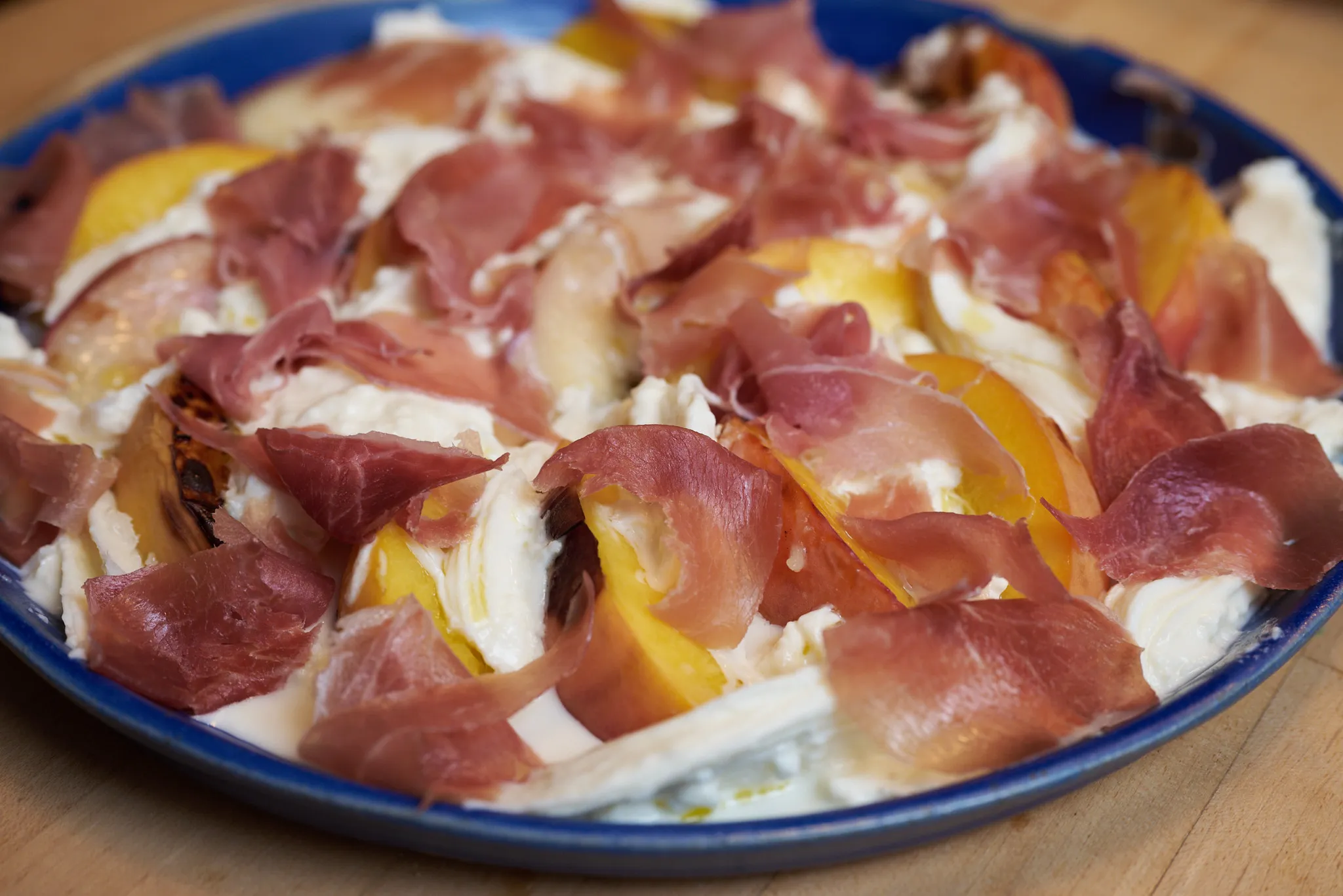 Burrata with thinly sliced prosciutto and grilled peaches