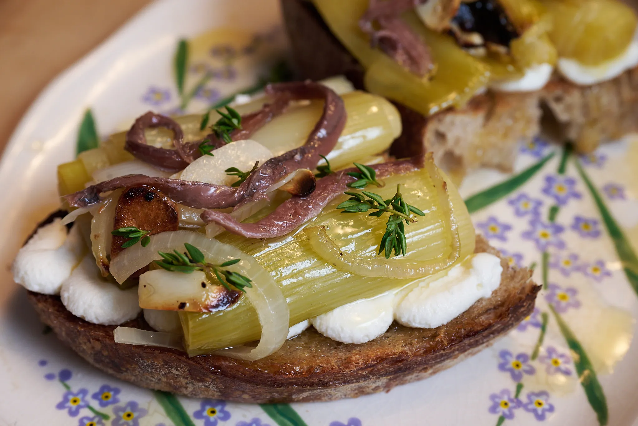 Braised leek toast with whipped ricotta, oregano oil, and anchovies