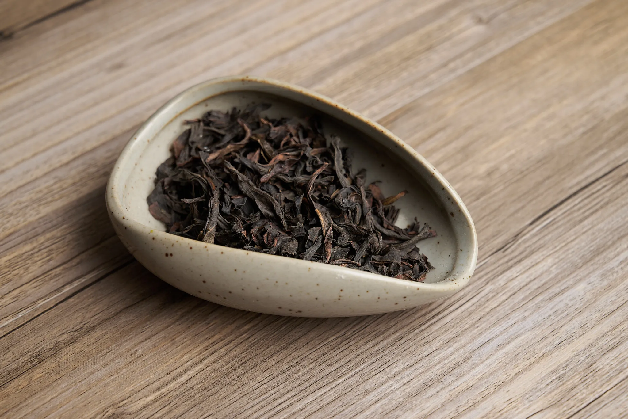 Dark rolled oolong tea leaves in a tray